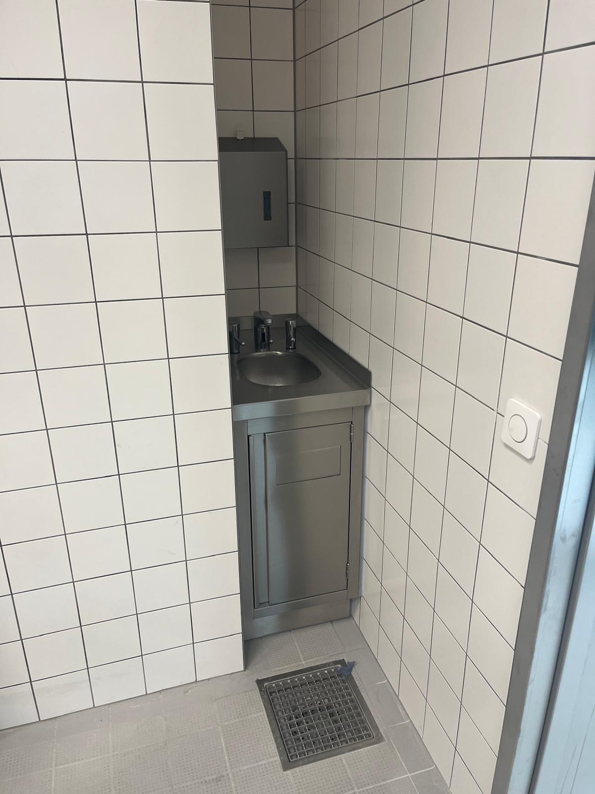 Eine von TIMMER maßangefertigte Küchentheke mit eingebautem Waschbecken, die sich der Schmalen Ecke einer bestehenden Räumlichkeit anpasst und jeden Platz nutzt