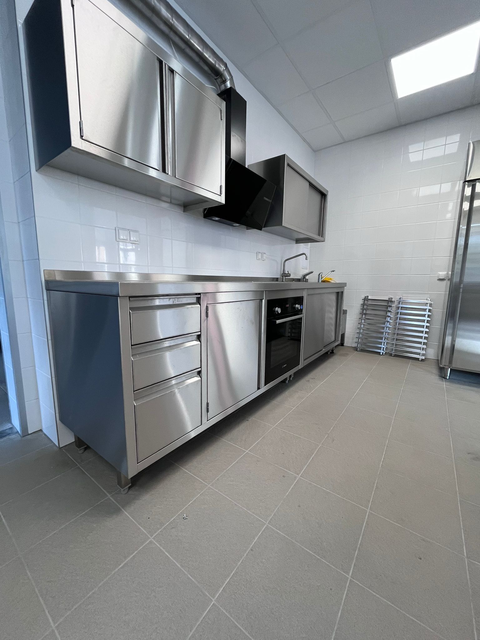 Eine von TIMMER gebaute Regenerierküche in einem Containerbau mit Edelstahltheken, einer Ausgabe und professionellen Großküchengeräten