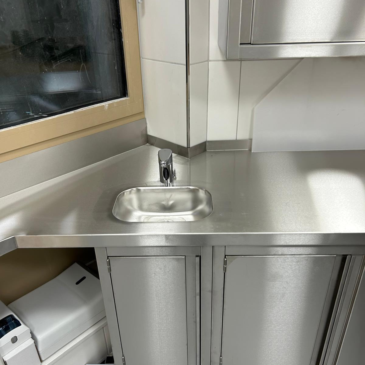 Eine von TIMMER maßangefertigte Küchentheke, die sich den Winkeln einer bestehenden Räumlichkeit anpasst und jeden Platz nutzt