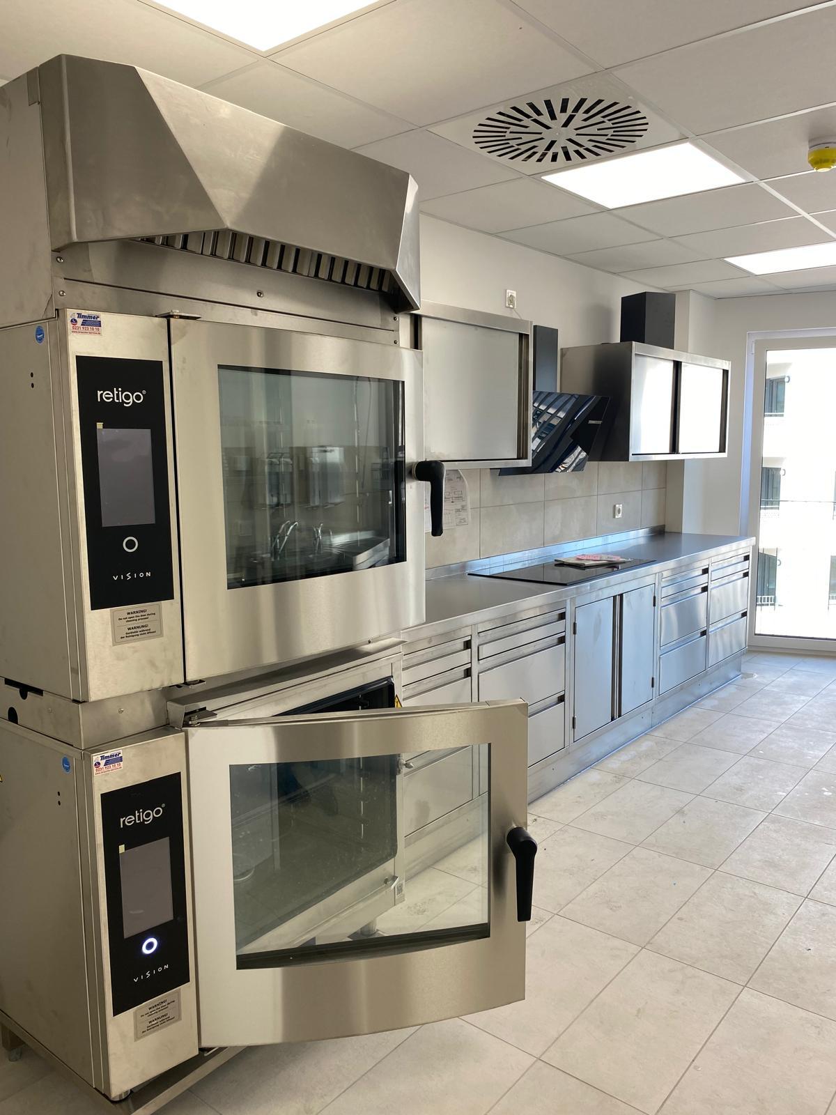 Eine von TIMMER geplante, maßangefertigte und installierte Systemküche mit Profiküchengeräten und individuellen Edelstahltheken